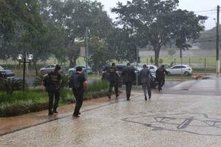 Equipe da Polícia Federal saindo do TJMS debaixo de chuva nesta manhã (Foto: Paulo Francis)