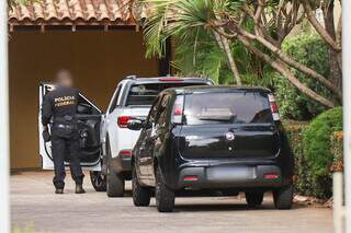 Carro dentro de condomínio sendo vistoriado por policial federal (Foto: Henrique Kawaminami)