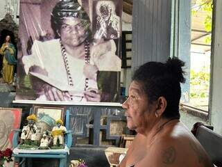 Natalícia, a dona Cotó fala da vinda da família em MS; ao fundo a foto de Mãe Cacilda e, no detalhe, Pai João de Minas (Foto: Marcos Maluf)