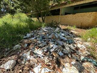 Lixo e entulho jogados no pátio da antiga escola, localizada na Avenida Guaicurus (Foto: Marcos Maluf)