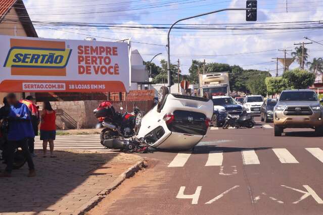 Motorista de aplicativo tenta desviar de moto, carro capota e deixa 2 feridos