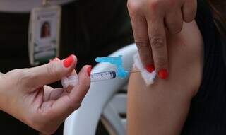 Profissional de saúde aplicando vacina no braço de paciente (Foto: José Cruz/Agência Brasil) 