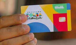 Beneficiário segura cartão do programa Bolsa Família (Foto: Agência Brasil)
