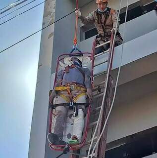 Vítima sendo retirada em um cesto prancha por equipe do Corpo de Bombeiros (Foto: Rádio Caçula)