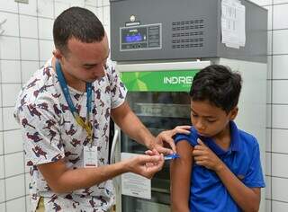 Menino recebe vacina contra dengue em posto de saúde de Campo Grande. (Foto: Divulgação PMCG)