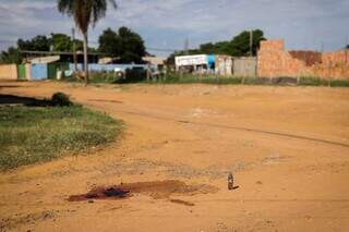 Marca de sangue e garrafa com liquído no local onde vítima foi morta (Foto: Henrique Kawaminami)