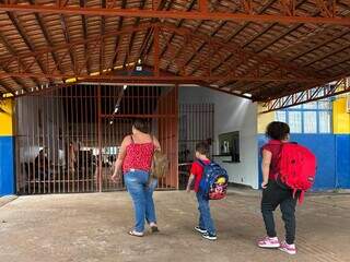 Franciele chegando com os dois filhos para deixar na escola, mas portão estava fechado (Foto: Marcos Maluf)