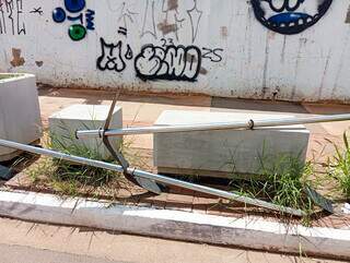 Estrutura de guard rail está quebrada e mato cresce em torno dos bancos na esquina da Rua Rui Barbosa com a Avenida Fernando Corrêa da Costa (Foto: Idaicy Solano)