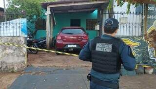 Policial em frente à casa onde homem foi morto pelo cunhado, em Dourados (Foto: Leandro Holsbach)