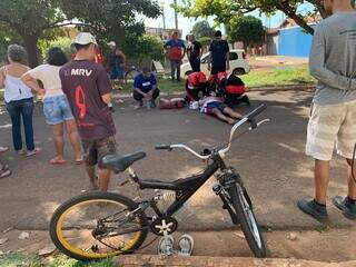 Ciclista deitado no chão após bater em porta de carro, na Rua Nove, no Bairro Nova Campo Grande (Foto: Bruna Marques)