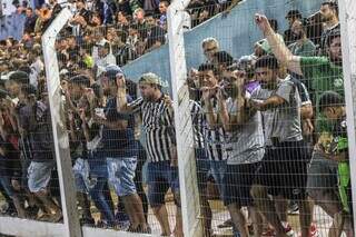 Sem espaço nas arquibancadas, torcedores assistem ao jogo na grade do Estádio Jacques da Luz. (Foto: Juliano Almeida)