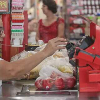 Caixa de supermercado digita valor do quilo da maça em Campo Grande. (Foto: Marcos Malu)