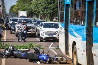 Motos e ônibus no cenário do acidente e atrás, fluxo de carros presos em congestionamento (Foto: Henrique Kawaminami)