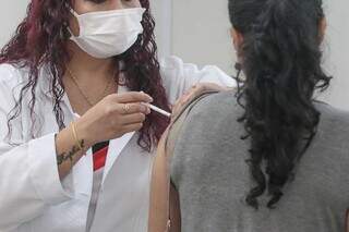Mulher recebe imunizante da gripe em unidade de saúde da Capital (Foto: Marcos Maluf)