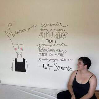Janaina Araujo e uma das paredes desenhadas à mão. (Foto: Arquivo pessoal)
