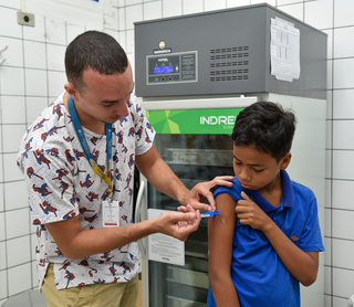 Profissional de saúde aplica dose de vacina contra a dengue em criança. (Foto: Reprodução/Sesau)