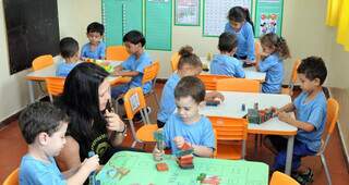 Assistente de educação infantil e alunos da rede municipal de Campo Grande durante atividade em sala de aula (Foto: Divulgação/PMCG)