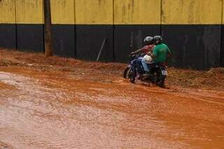 Motociclista passa pela Rua Urupês, alagada após chuva em março de 2023 (Foto: Arquivo/Campo Grande News/Henrique Kawaminami)
