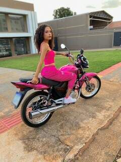 Com look rosa, Edilene montada na moto que reformou. (Foto: Arquivo pessoal)