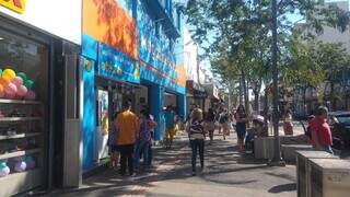 Consumidores passando em frente de lojas na Rua 14 de Julho (Foto: Izabela Cavalcanti)