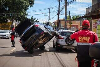 Carro em cima de outro em via do Jardim Leblon e bombeiros que foram chamados para a ocorrência. (Foto: Henrique Kawaminami)