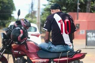 Motociclista sentado no veículo estacionado, enquanto conversa com a reportagem (Foto: Marcos Maluf)