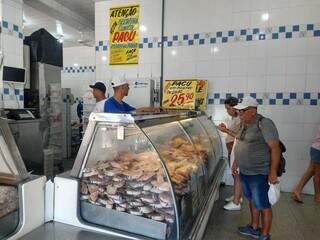 Ademar escolhendo peixe para comprar e assar na sexta-feira santa (Foto: Izabela Cavalcanti)