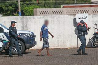 Homem, de 29 anos, que fez mulher refém sendo escoltado por dois policiais para a delegacia (Foto: Marcos Maluf)