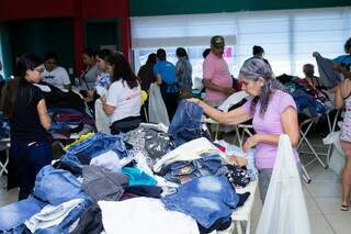 Consumidores escolhem roupas disponíveis no bazar da AACC/MS (Foto: divulgação)