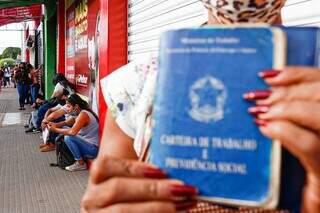 Mulher segura Carteira de Trabalho na fila da Funtrab. (Foto: Paulo Francis)