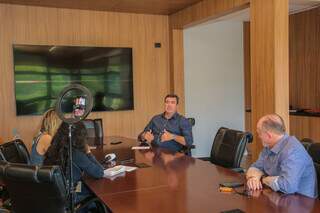 O governador Eduardo Riedel (centro) durante entrevista à equipe do Campo Grande News. (Foto: Paulo Francis)
