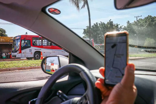 Motorista de aplicativo circula ao lado de ônibus na Capital. (Foto: Arquivo/Campo Grande News)