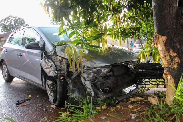 Carro bate em &aacute;rvore ao tentar desviar de ciclista durante forte chuva 