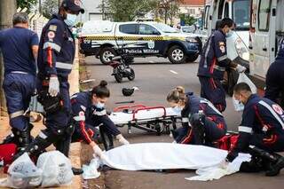 Depois de tentar de tudo, socorristas cobrem o corpo de Emerson Jesus Antunes Braga, uma das vítimas que morreu no trânsito (Foto: Henrique Kawaminami) 