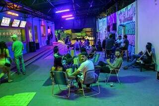 Área coberta tem luzes neon, cadeiras de praia e paredes grafitadas; espaço também abriga as torneiras de chope e o bar (Foto: Juliano Almeida)