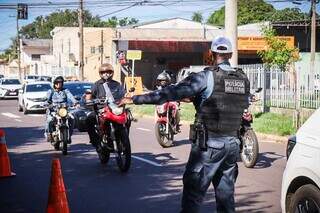 Policial indicando parada aos motociclistas (Foto: Henrique Kawaminami)