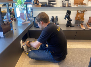 Leopoldo tentando consertar equipamento que faz iluminação da vitrine (Foto: Clara Farias)