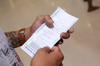Apostador segura volante e comprovante de aposta em agência lotérica de Campo Grande. (Foto: Arquivo/Marcos Maluf)