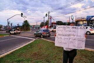 Com cartazes, venezuelana pede apoio financeiro em avenida da Capital (Foto: Kisie Ainoã/Arquivo)