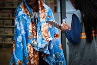 Agente da prefeitura atende morador de rua e entrega cobertor (Foto/Arquivo/Henrique Kawaminami)