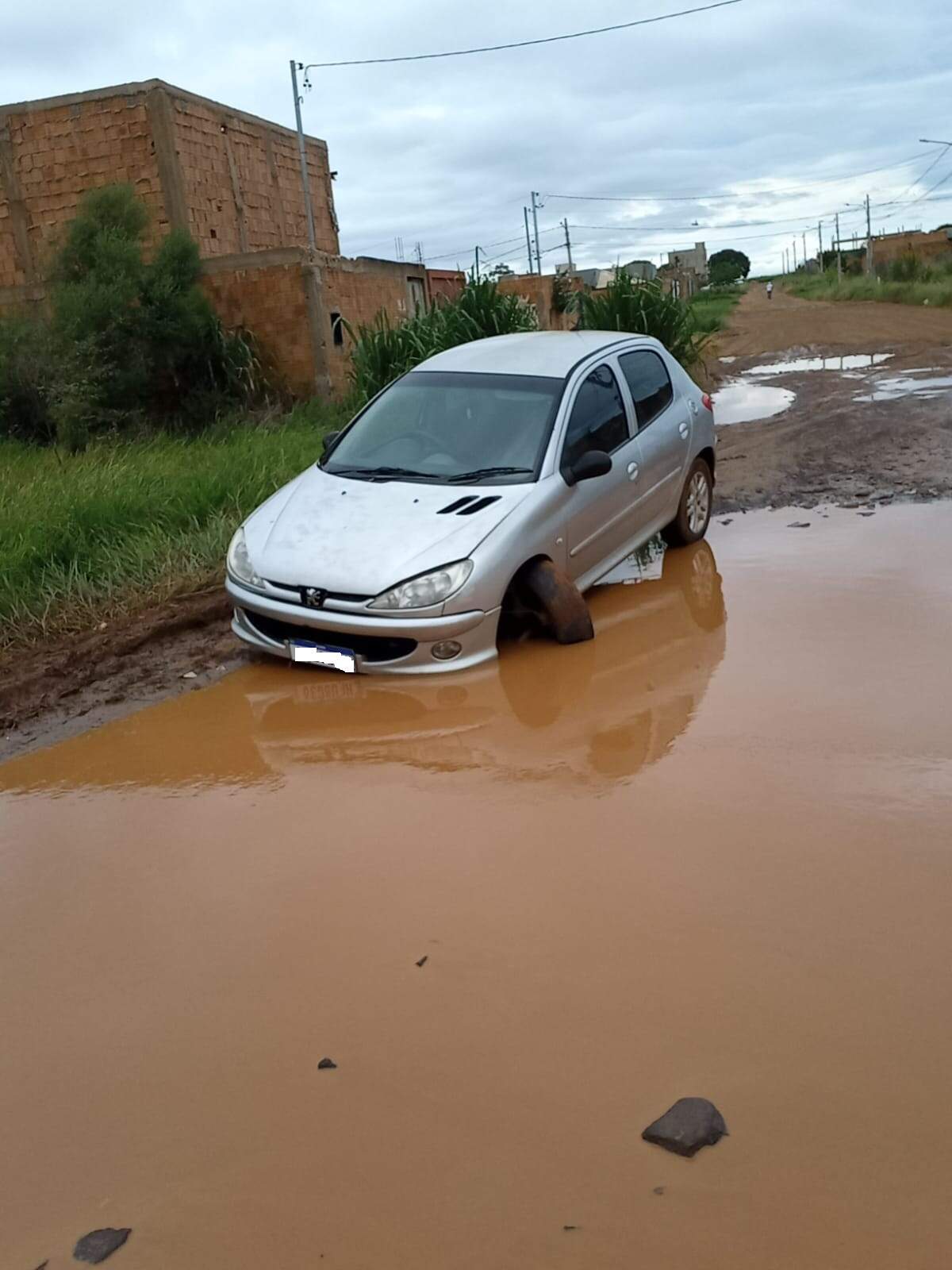 Carro cai em buraco escondido por rua alagada no Recanto do Cerrado 