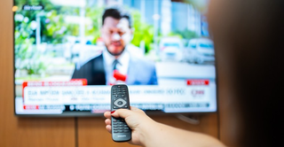 Telespectadora troca o canal do seu aparelho televisor utilizando função do controle remoto. (Foto: Shizuo Alves/Ministério da Comunicação)