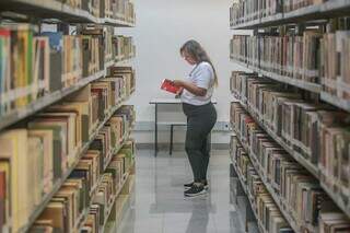 Mariela folheando livros durante a visita. (Foto: Marcos Maluf)