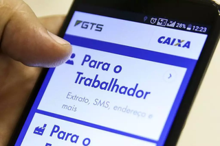 Trabalhador de carteira assinada verifica o saldo do fundo no aplicativo da Caixa. (Foto: Marcelo Camargo/Agência Brasil)