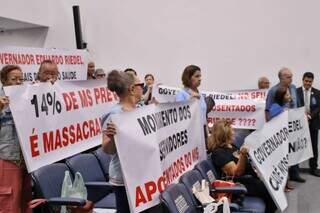 Aposentados segurando faixas em protesto na Assembleia (Foto: Paulo Francis)