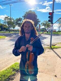 Hegell e seu violino na Avenida Conssul Assaf Trad, em Campo Grande (Foto: Cassia Modena)