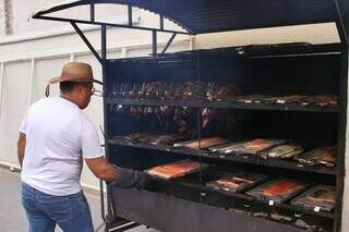 Clodoaldo assando peixes que clientes pediram sob encomenda para retirar na manhã de hoje (Foto: Paulo Francis)
