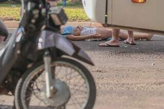 Motociclista teve leves escoriações na perna e aguarda atendimento deitada no asfalto (Foto: Marcos Maluf)