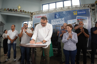 Ao lado da senadora Tereza Cristina (PP), Alan Guedes assina ordens de serviço do programa Desenvolve Dourados. (Foto: Reprodução)