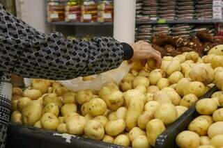 Consumidora escolhe batatas no mercado, produto que teve maior redução nos preços (Foto: Paulo Francis)